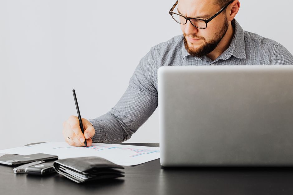Confident real estate professional sits at a modern, bright desk, strategically planning on a laptop, symbolizing the proa...