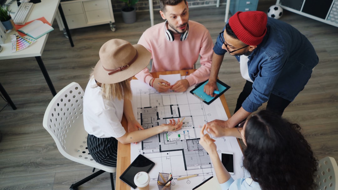 Diverse team of real estate agents collaborating around a conference table in a bright, modern office, symbolizing the tea...