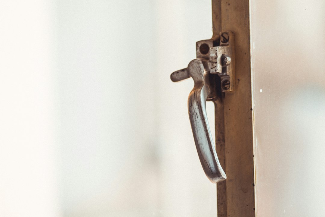 Close-up shot of a modern key smoothly turning in the lock of a minimalist front door, symbolizing easy access and unlocki...
